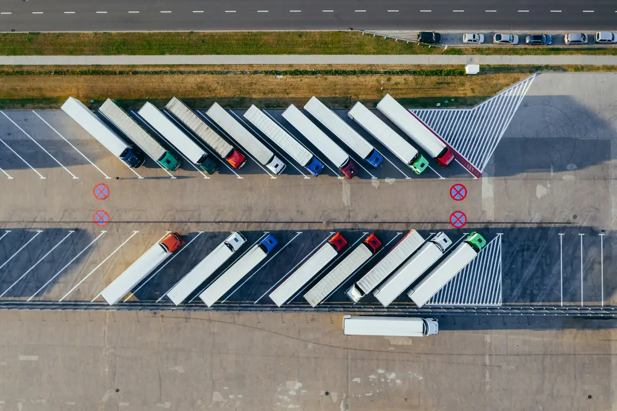 Logisztikai udvaron sorokban parkoló kamionok felülnézetből